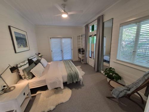 a bedroom with a bed and a desk and a window at Finchy Cottage in Beechworth