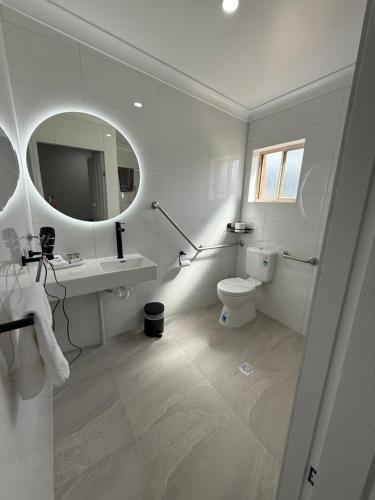 a bathroom with a toilet and a sink and a mirror at Mia Motel in Griffith