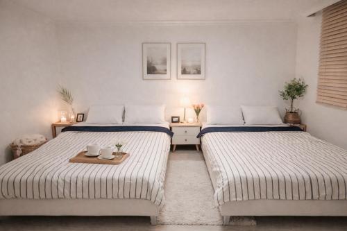 two beds in a room with a table and two beds at stay young in Suwon