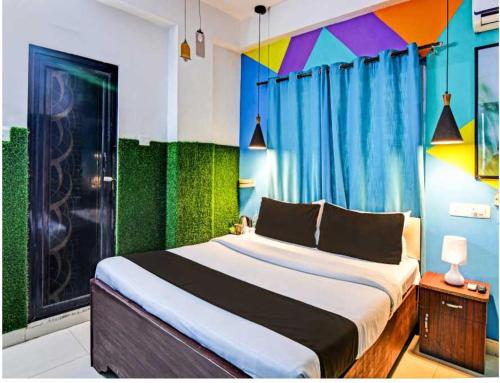 a bedroom with a large bed with colorful curtains at Hotel O Krishna Bhawan in kolkata