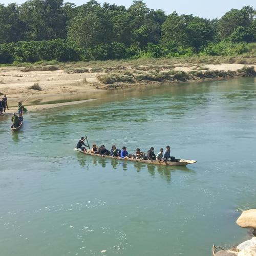 a group of people in a boat on a river at Chitwan Paradise Hotel in Sauraha
