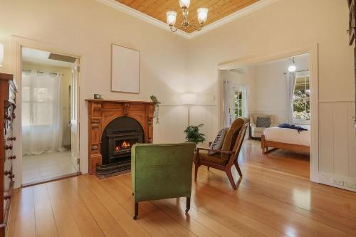 a living room with a fireplace and a table and chairs at Marianna's Lakeside Cottage in Beechworth