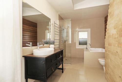 a bathroom with a sink and a tub and a toilet at Marianna's Lakeside Cottage in Beechworth
