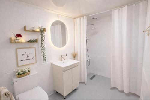 a white bathroom with a sink and a mirror at stay young in Suwon