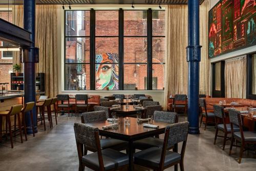 a restaurant with tables and chairs and a large window at The Bankers Alley Hotel Nashville, Tapestry Collection by Hilton in Nashville