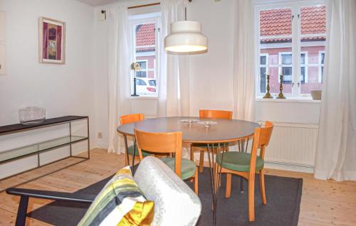a living room with a dining room table and chairs at 3 Bedroom Nice Home In Simrishamn in Simrishamn