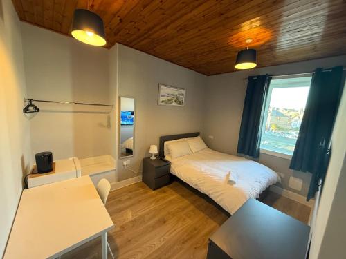ein Schlafzimmer mit Bett, Schreibtisch und Fenster in der Unterkunft Peterhead contractor accommodation in Peterhead
