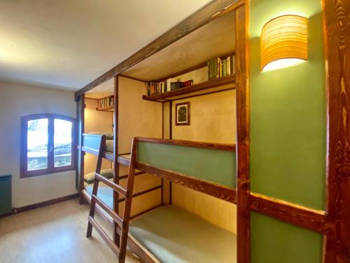 a room with a bunk bed and a staircase at Shangri-La Travellers' Hostel in Castel dellʼAlpi