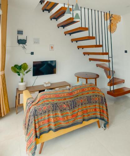a bedroom with a bed and a spiral staircase at Pakuhaji Highland Ecoresort in Panjadakan