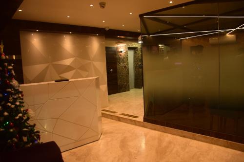 a room with a christmas tree and a glass wall at The Opus Kolkata - A Boutique Hotel in Kolkata