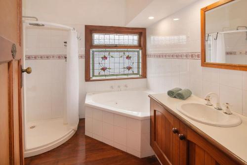 a bathroom with a tub and a sink and a shower at Busselton Central Accommodation in Busselton