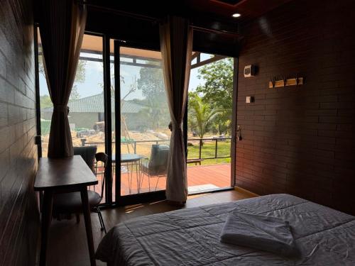 a bedroom with a bed and a large window at Sand and Sun Koh Rong in Kaôh Rŭng