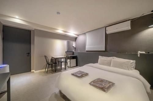 a bedroom with a large white bed and a table at Hotel HL in Seoul