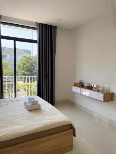 a bedroom with a bed and a large window at Bắp Villa Huế in Thôn Lại Thê