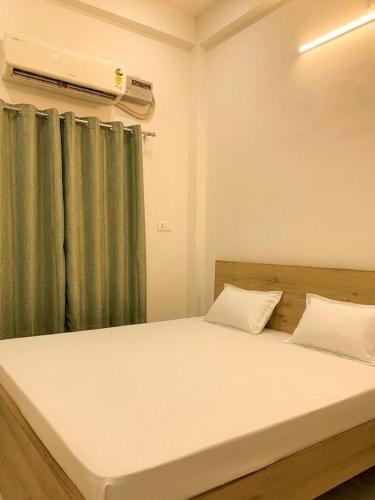 a bedroom with a bed with a green curtain at Privyrooms Taramandal in Gorakhpur