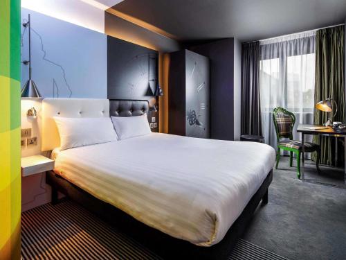 a hotel room with a large bed and a desk at ibis Styles London Southwark - near Borough Market in London