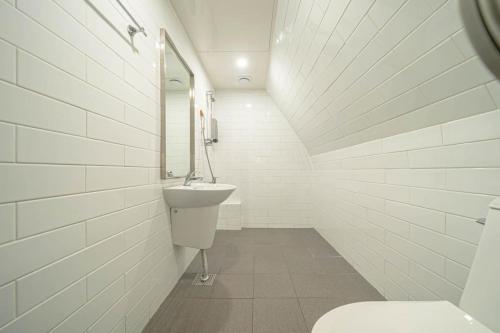 a white bathroom with a sink and a toilet at Hotel HL in Seoul