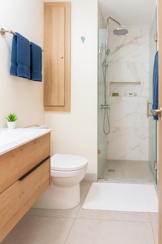 a bathroom with a toilet and a shower with blue towels at Boca del mar III in Boca Chica