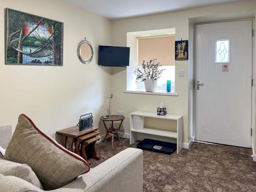 a living room with a couch and a tv at The Stable Room - Uk51595 in Berwick-Upon-Tweed