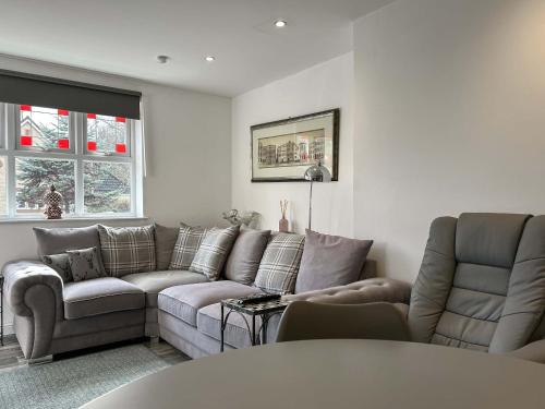 a living room with a couch and two chairs at Peebles Apartment in Peebles