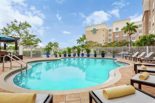 a swimming pool at a hotel with lounge chairs at Homewood Suites Fort Myers Airport - FGCU in Fort Myers