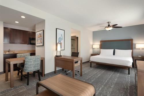 a hotel room with a bed and a kitchen at Homewood Suites Fort Myers Airport - FGCU in Fort Myers