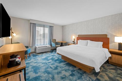 ein Hotelzimmer mit Bett und Flachbildfernseher in der Unterkunft Hampton Inn Harrison in Harrison
