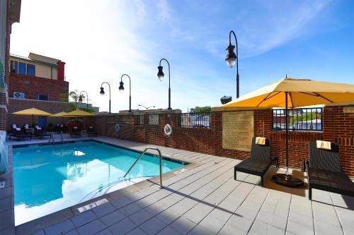 a swimming pool with two chairs and an umbrella at Hilton Garden Inn Savannah Historic District in Savannah