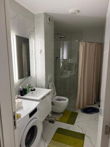 a white bathroom with a toilet and a shower at Lux stan in Bar