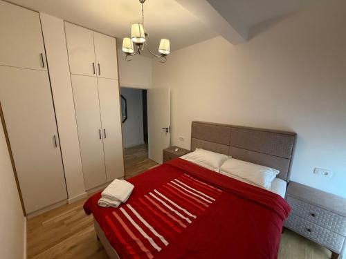 a bedroom with a bed with a red blanket at Lux stan in Bar
