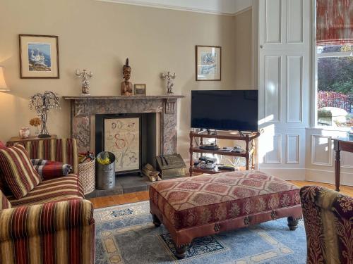 a living room with a fireplace and a tv at Embleton House - Uk51597 in Berwick-Upon-Tweed