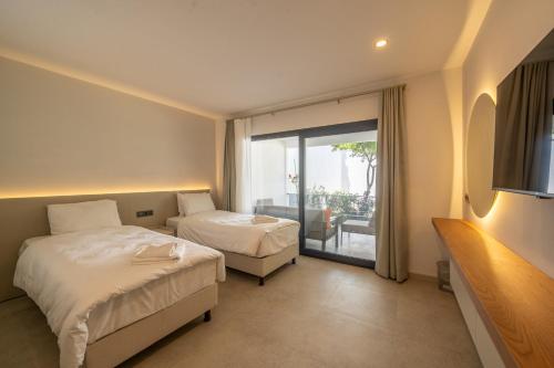 a hotel room with two beds and a balcony at Orkide Bodrum in Bodrum City