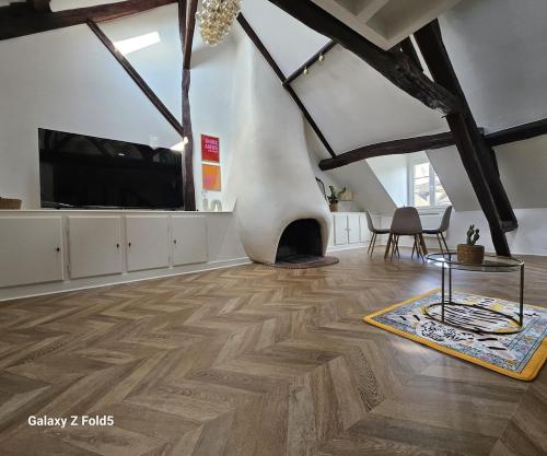 a living room with a tv and a wooden floor at La Cathedrale in Senlis
