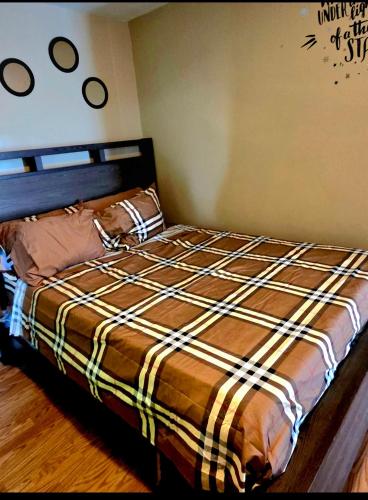 a bedroom with a bed with a plaid blanket at Comfortable & Relaxing Charming 3BR unit in Chicago