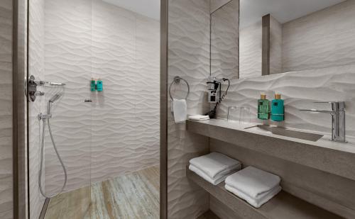 a bathroom with a shower and a sink at Beachhouse Hotel in Zandvoort