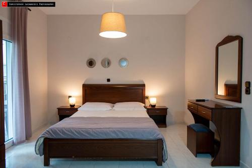a bedroom with a bed and a vanity and a mirror at Mokos Rooms in Perdika