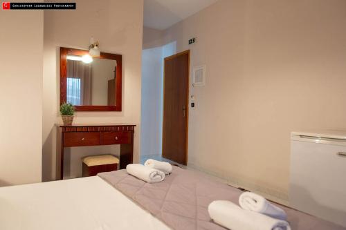 a bedroom with a bed and a sink and towels at Mokos Rooms in Perdika