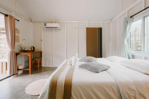 a bedroom with a large bed with white sheets and pillows at สะปันดีวิว Sapan Dee View บ่อเกลือ น่าน in Ban Huai Ti