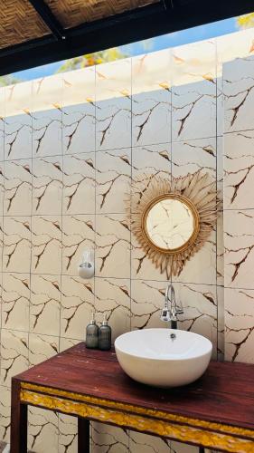 a bathroom with a sink and a tile wall at Sun Resort And Villa Gili Trawangan in Gili Trawangan