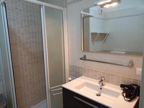 a bathroom with a sink and a shower with a mirror at Corte DON BOSCO 5 in Monfalcone