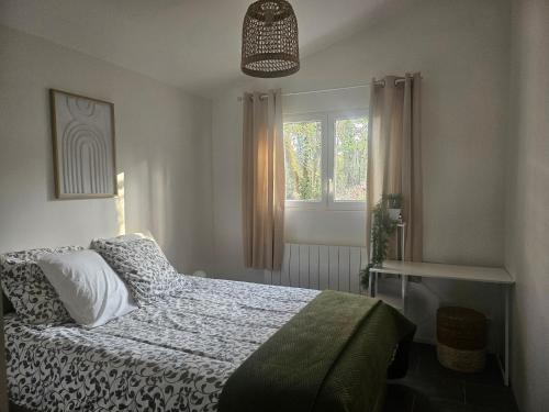 a bedroom with a bed and a window at Gîte Les Durands in Cahors
