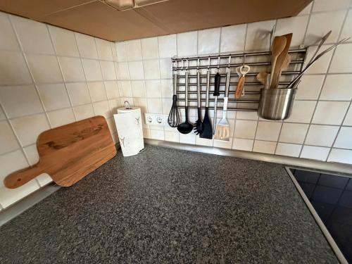 a kitchen counter with a wooden cutting board and utensils at Black Forest Sports Loft in Achern
