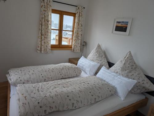 a bedroom with a bed with pillows and a window at Rieplhof in Samerberg