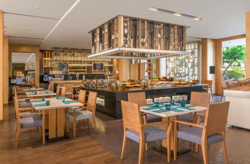 a restaurant with tables and chairs and a bar at Hilton Bangkok Suvarnabhumi Golf Resort & Spa in Lat Krabang