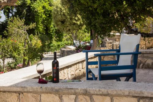 a bottle of wine and a glass on a table at Iliopetra in Douliana