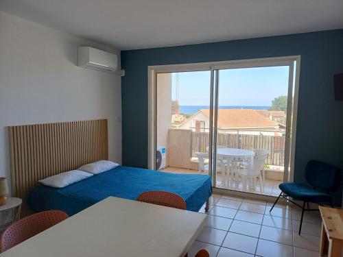 a bedroom with a bed and a view of a balcony at Studio vue mer in Cervione