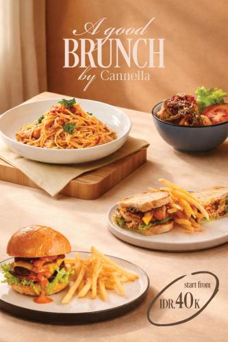 a table with plates of food and a bowl of pasta at Cannella Suites Ubud - Ubud Center prime location in Ubud