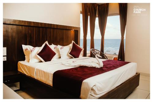 a bedroom with a bed with a view of the ocean at hotel church park in Velankanni