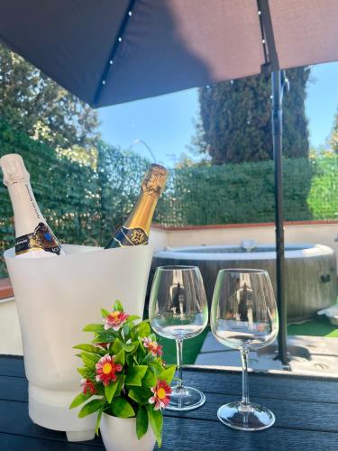 a table with three wine glasses and a plant at Empoli Charm in Empoli