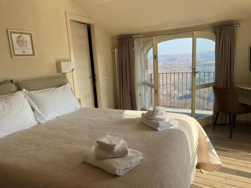 a hotel room with a bed with towels on it at Le Mongolfiere in Mondovì